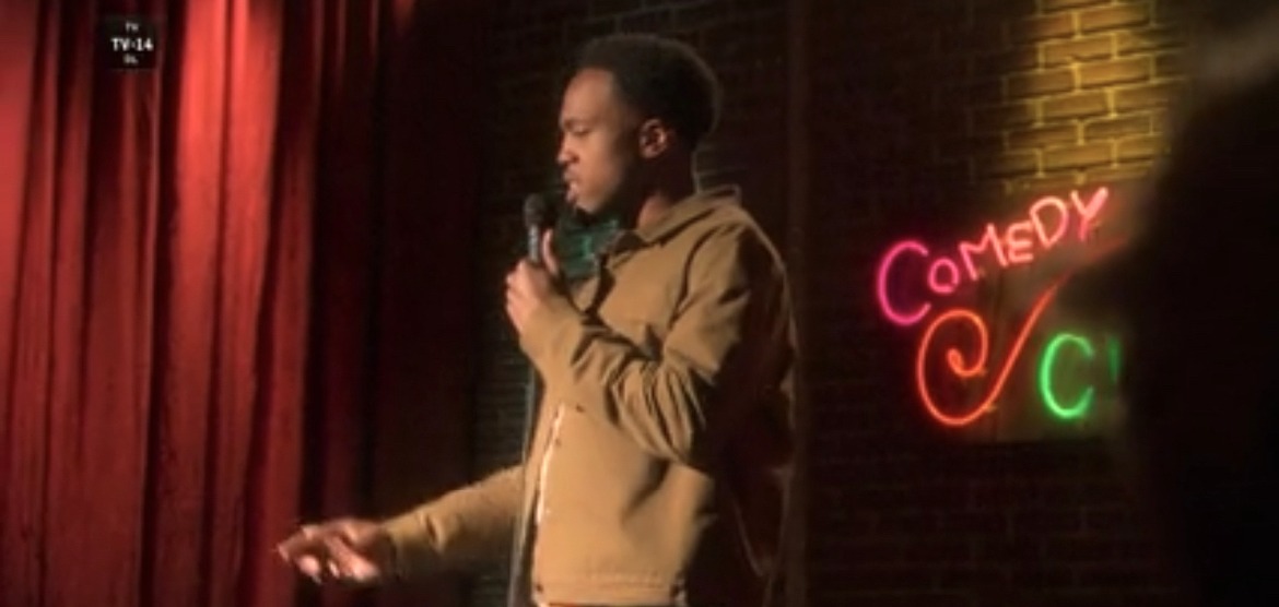Tash Jordan performing stand-up on stage in a scene from grown-ish