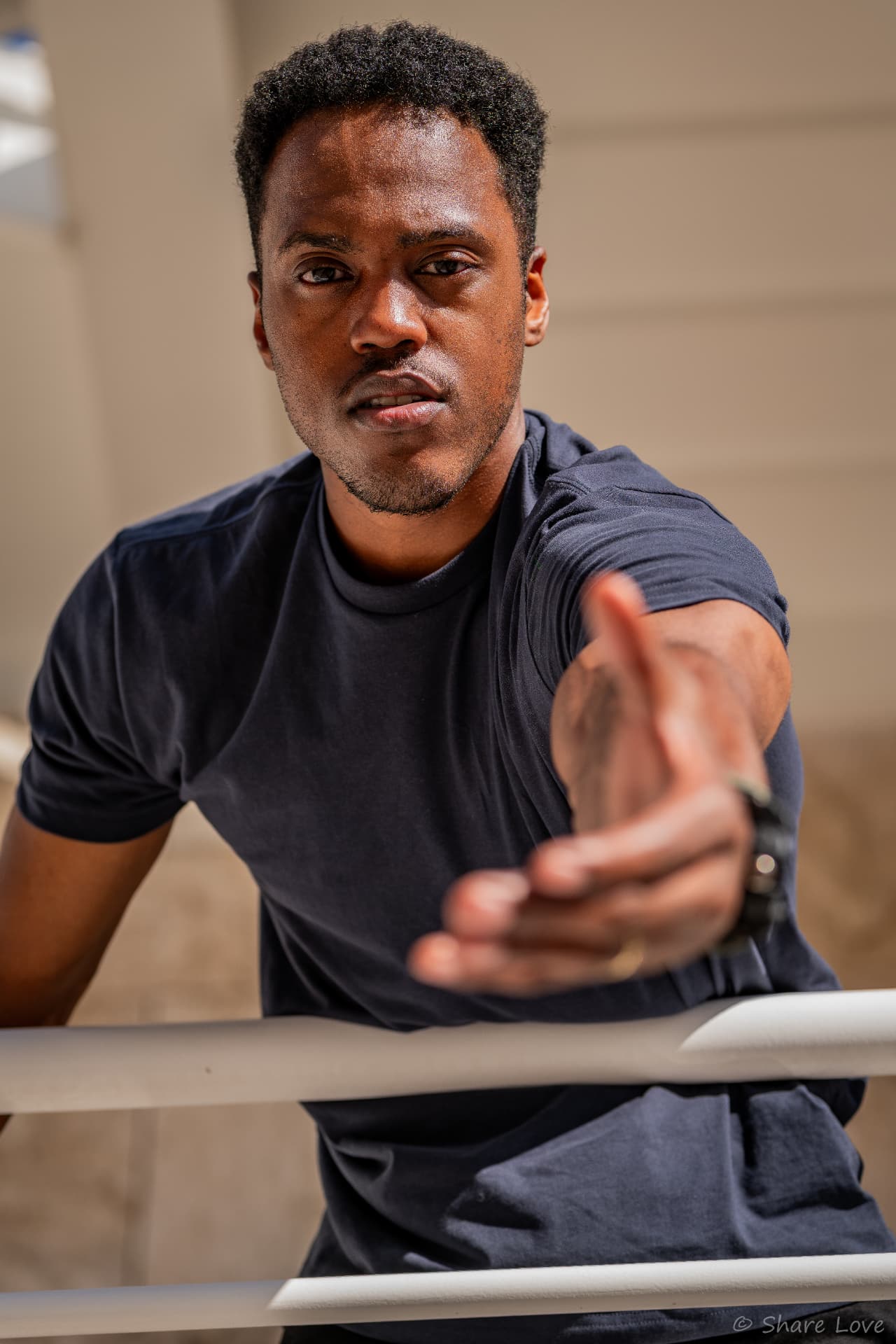 Tash Jordan reaching toward the camera over a white railing